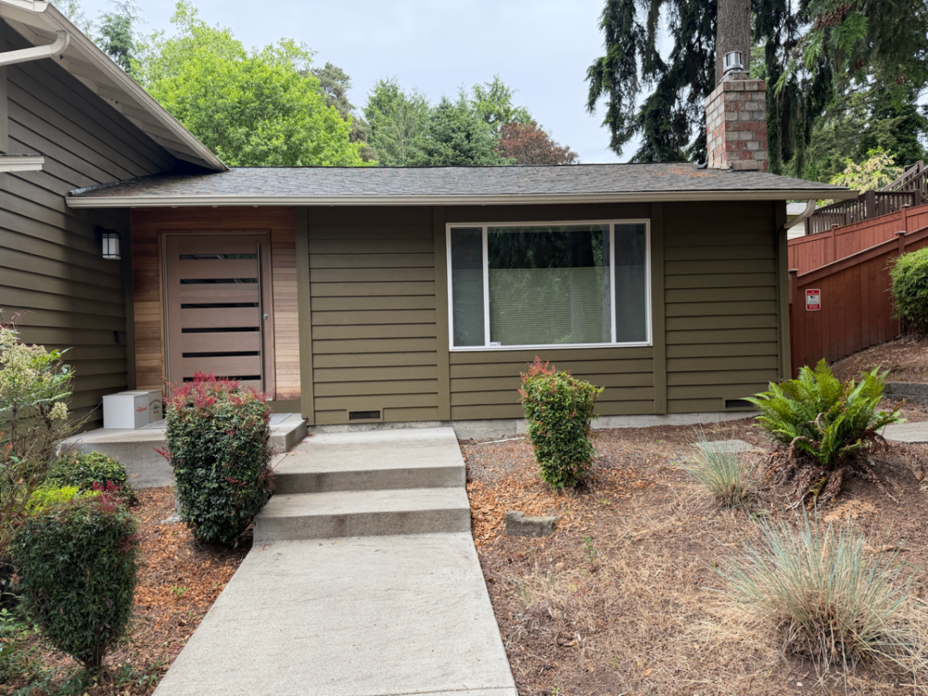 Front entry and walkway of an olive-green repainted home with refreshed siding