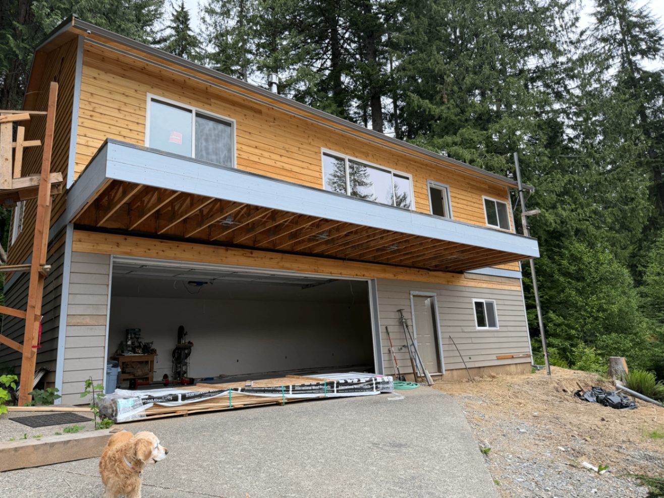 Early construction view of the lakefront custom home with exposed cedar before painting